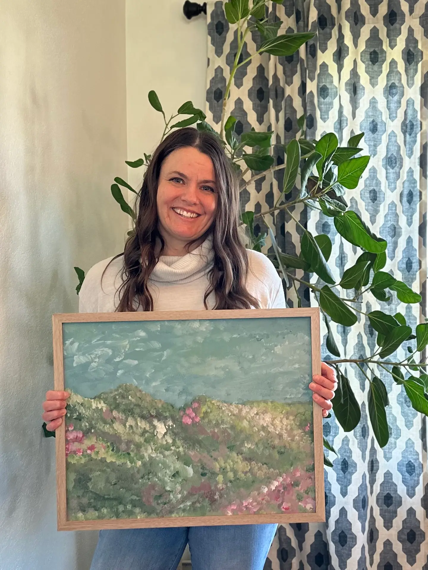 Photo of the artist, Jill Hillemeyer, holding one of her paintings